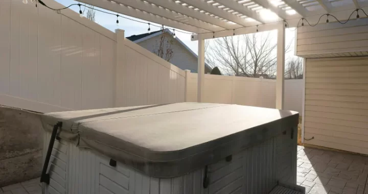 square outdoor hot tub covered with beige tarp pool cover